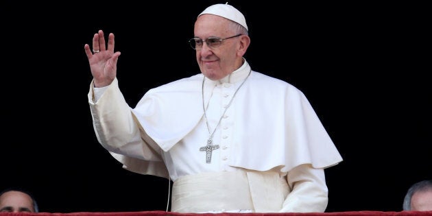 Pope Francis waves as he arrives to deliver the