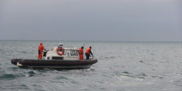 Russian rescuers carry a stretcher with passenger belongings after a Russian military plane crashed in the Black Sea, on a pier outside Sochi, on December 25, 2016.The Russian military plane crashed on its way to Syria on December 25, with no sign of survivors among the 92 onboard, who included dozens of Red Army Choir members heading to celebrate the New Year with troops. Russia's defence ministry said a body had been recovered from the Black Sea. / AFP / STRINGER (Photo credit should read STRINGER/AFP/Getty Images)