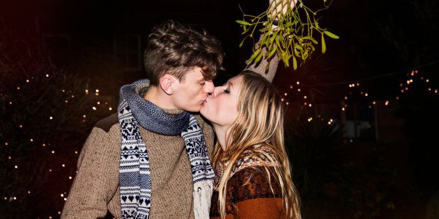 Couple kissing outdoors under mistletoe