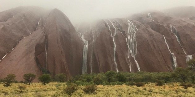 Rain cascades down Uluru.