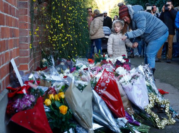 A woman and child look at tributes outside the house of singer George Michael, where he died on Christmas Day, in Goring, southern England, Britain December 26, 2016. REUTERS/Eddie Keogh