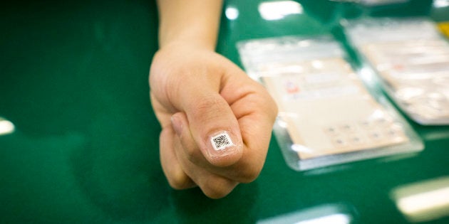 A government employee demonstrate the QR nail sticker to a thumb to help track down the elderly by smartphone at Iruma City Office, Saitama Prefecture, Japan on December 16, 2016. The Iruma City Government presented their tiny nail stickers, each of which contains a unique identity number for senior citizens with dementia, on Friday. A tagging system, part of a free service launched this month and a first in Japan, has been developed for the elderly who may get lost due to their illness. (Photo by Richard Atrero de Guzman/NURPhoto)