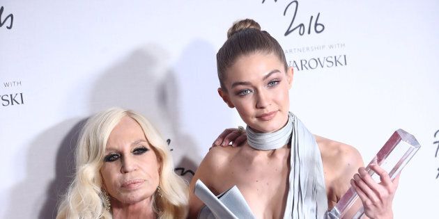 Gigi Hadid, winner of the International Model award (R) and designer Donatello Versace pose for photographers at the Fashion Awards 2016 in London, Britain December 5, 2016. REUTERS/Neil Hall