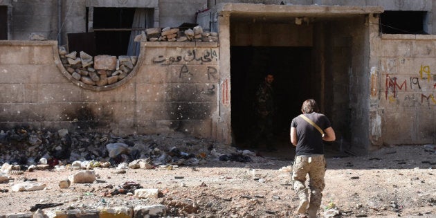 A Syrian pro-government soldier runs for cover in the '1070' apartment block area, south of al-Hamdaniyah, in eastern Aleppo