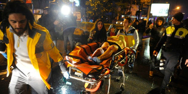 First aid officers carry an injured woman at the site of an armed attack on January 1, 2017 in Istanbul.