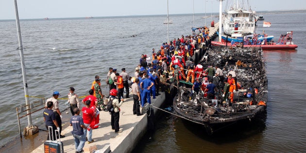 Police, Red Cross and rescue workers search a boat for victims at Muara Angke port in Jakarta, Indonesia, January 1, 2017. (REUTERS/Darren Whiteside)