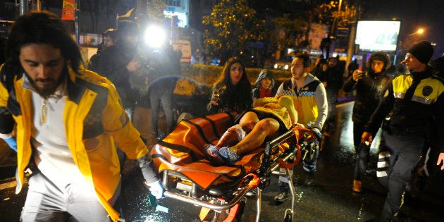First aid officers carry an injured woman at the site of an armed attack on January 1, 2017 in Istanbul.