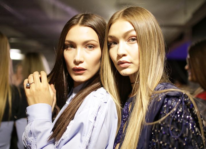 The sisters, at a fashion show in Milan, both look striking wioth super straight hair.