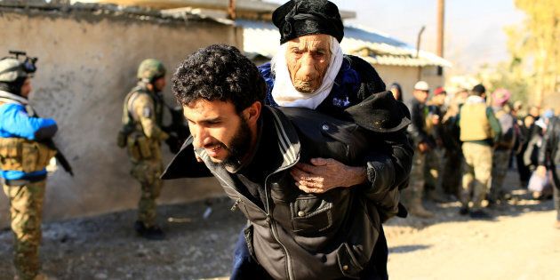 A displaced man, who fled the Islamic State stronghold of Mosul, carries a woman in the Mithaq district of eastern Mosul, Iraq, January 3, 2017.