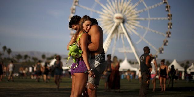 A couple hugs in front of the ferris wheel at the Coachella Valley Music and Arts Festival in Indio, California April 10, 2015. REUTERS/Lucy Nicholson TPX IMAGES OF THE DAY