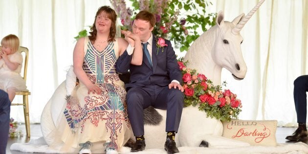 The newlyweds sitting atop their unicorn throne.