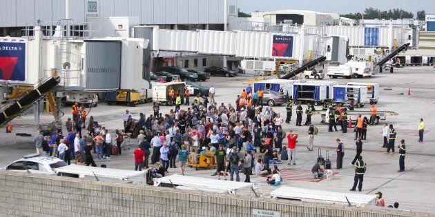 People wait on the Tarmac at Fort Lauderdale-Hollywood International Airport after a reported shooting