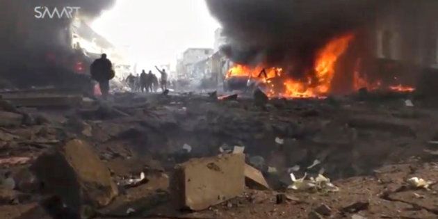 An image grab taken from an AFPTV video released on January 7, 2017 shows people gathering amidst the debris at the site of a car bomb attack in the rebel-held town of Azaz in northern Syria.According to the Syrian Observatory for Human Rights, at least 43 people were killed and dozens injured in the blast that ripped through the town near the Turkish border. / AFP / AFPTV / STRINGER (Photo credit should read STRINGER/AFP/Getty Images)