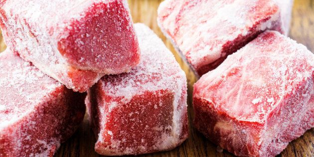 Frozen beef slices in hoarfrost close up