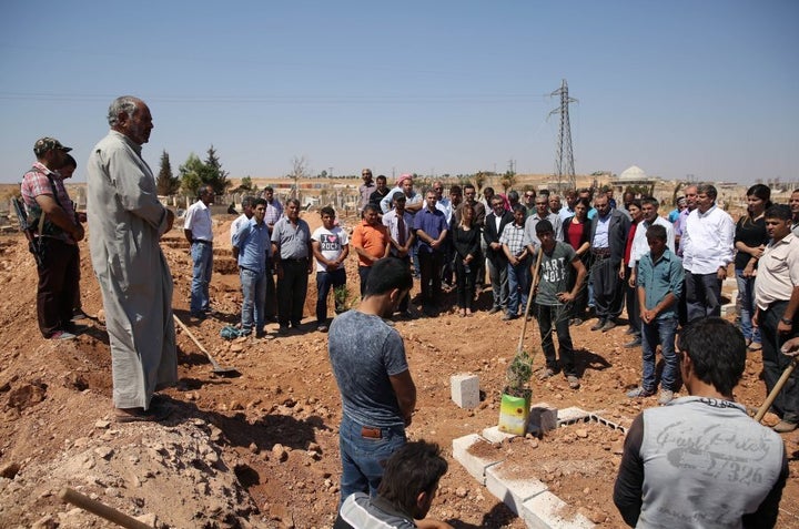 Abdullah Kurdi attends the burial of his son Aylan and brother Galip and his wife Zahin, who were buried in Kobani, Syria, after they drowned en route from Turkey to the Greek islands in the Aegean Sea.