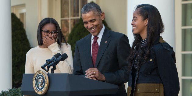 US President Barack Obama laughs with daughters Malia (R) and Sasha before 'pardoning' the National Thanksgiving Turkey in the Rose Garden at the White House in Washington, DC, on November 25, 2015. The President pardoned Honest and his alternate Abe, both 18-week old, 40-pound turkeys. The names of the turkeys were chosen from submissions from California school children. After the pardoning, the turkeys will be on display for visitors at their permanent home at Morven Parks Turkey Hill, the historic turkey farm located at the home of former Virginia Governor Westmoreland Davis (1918-1922) in Leesburg, Virginia. AFP PHOTO/NICHOLAS KAMM / AFP / NICHOLAS KAMM (Photo credit should read NICHOLAS KAMM/AFP/Getty Images)