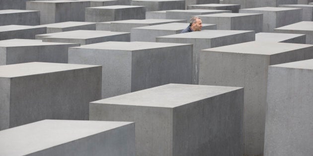 GERMANY, BERLIN - APRIL 04: A visitor between the stelae of the Holocaust Memorial in Berlin. (Photo by Ulrich Baumgarten via Getty Images)