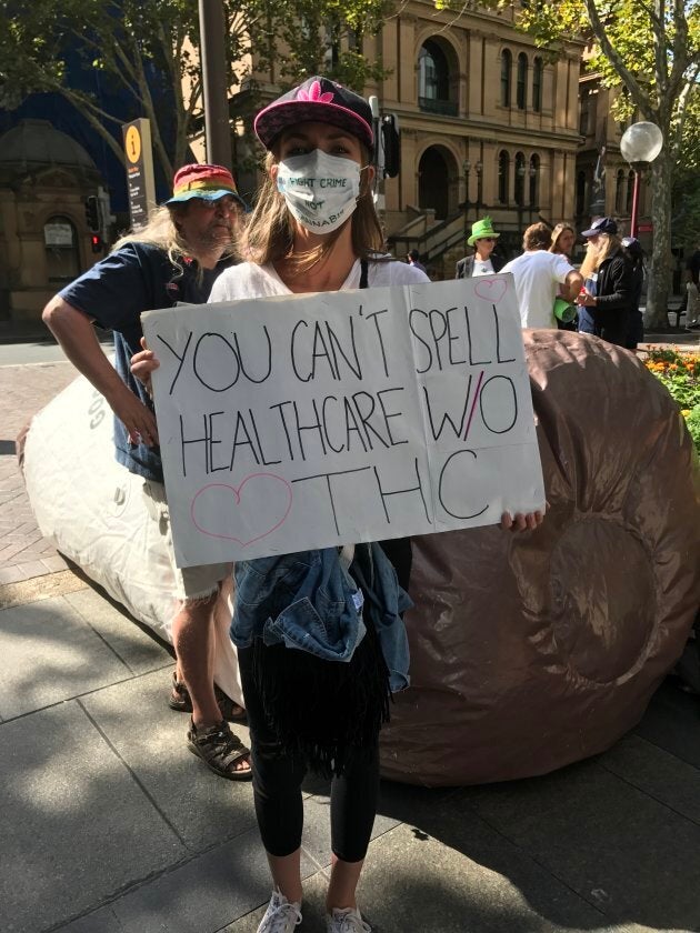 A protester stands across the road from NSW parliament on Tuesday to demand better access to medical cannabis.