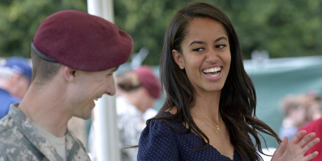 Malia Obama, daughter of US President, (R) smiles as she serves food during a lunch at the United States and Nato military base in Vicenza on June 19, 2015 . AFP PHOTO / ANDREAS SOLARO (Photo credit should read ANDREAS SOLARO/AFP/Getty Images)