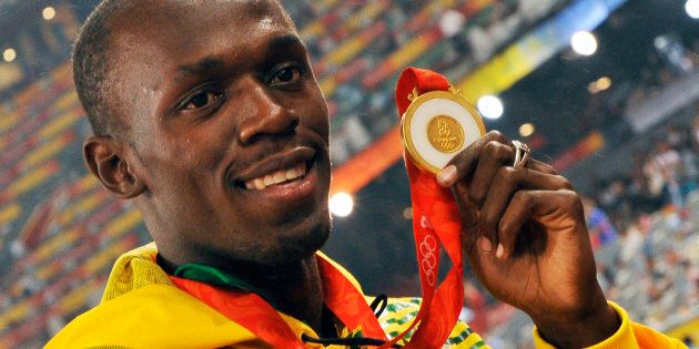 Usain Bolt with his gold medal. (Photo by Eddy LEMAISTRE/Corbis via Getty Images)