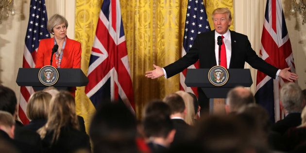 President Donald Trump gestures toward British Prime Minister Theresa May during their news conference in the East Room of the White House in Washington, Friday, Jan. 27, 2017. (AP Photo/