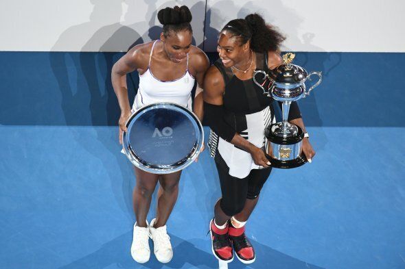 Serena Williams of the US holds the championship trophy after her victory in the women's singles final match against her sister Venus Williams of the US (L) on day 13 of the Australian Open tennis tournament in Melbourne on January 28, 2017. / AFP / SAEED KHAN / IMAGE RESTRICTED TO EDITORIAL USE - STRICTLY NO COMMERCIAL USE (Photo credit should read SAEED KHAN/AFP/Getty Images)