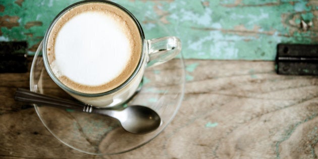 Cup of coffee on wooden table. process in retro styled