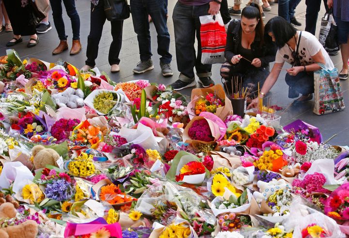 People look at floral tributes at Bourke St Mall for victims of the Bourke Street Mall Attack.
