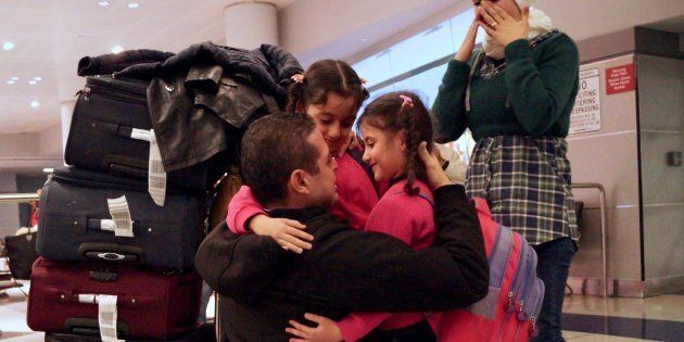 Fadi Kassar (L), hugs his daughters Hnan, 8 and Lian, 5 for the first time in more than 2 years as his wife Razan looks on after the family was reunited at John F. Kennedy International airport in New York City following a flight from Amman, Jordan, February 2, 2017. HIAS, The global Jewish nonprofit that protects refugees, assisted the Syrian family after their initial reunion attempt was unsuccessful. Despite having valid travel documents, the mother and 2 children were not permitted to board a flight to New York in Kiev, Ukraine 1/28/17, the day after US President Donald Trump signed an executive order banning entry of citizens from 7 predominantly Muslim countries. Photo Mandatory Credit:Bill Swersey/HIAS.org