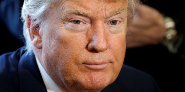 U.S. President Donald Trump looks up after signing an executive order rolling back regulations from the 2010 Dodd-Frank law on Wall Street reform at the White House in Washington February 3, 2017. REUTERS/Kevin Lamarque