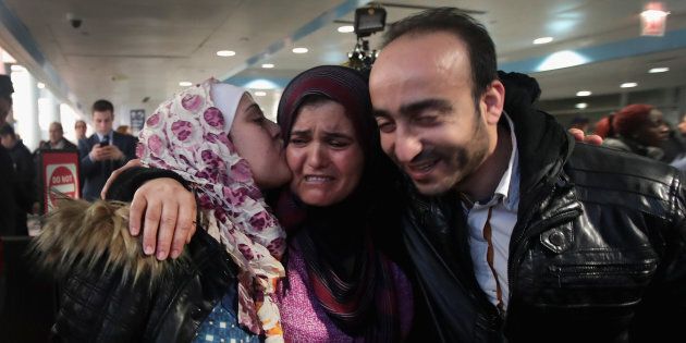 Syrian refugee Baraa Hajj Khalaf, left, and her husband, Abulmajeed, are greeted by her mother, Fattuom, after a second-attempt flight from Turkey to Chicago on Feb. 7.