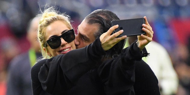 Lady Gaga gets a kiss from Christian Carino before Super Bowl LI.