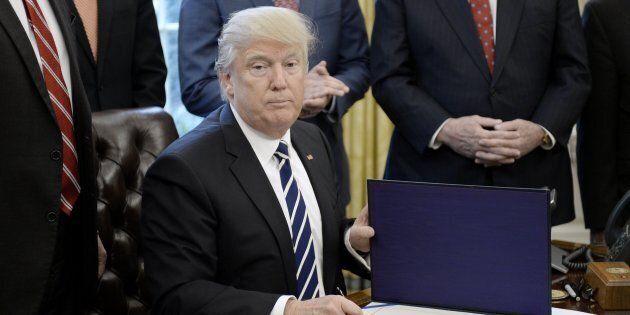 WASHINGTON, D.C. - FEBRUARY 14: (AFP-OUT) U.S. President Donald Trump signs H.J. Res. 41 in the Oval Office of the White House on February 14, 2017 in Washington, DC. The resolution nullifies a rule in the Dodd-Frank Act that 'requires resource extraction issuers to disclose payments made to governments for the commercial development of oil, natural gas, or minerals.' (Photo by Olivier Douliery-Pool/Getty Images)
