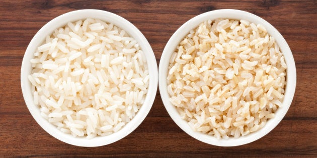 Top view of two bowls containing white and brown boiled rice