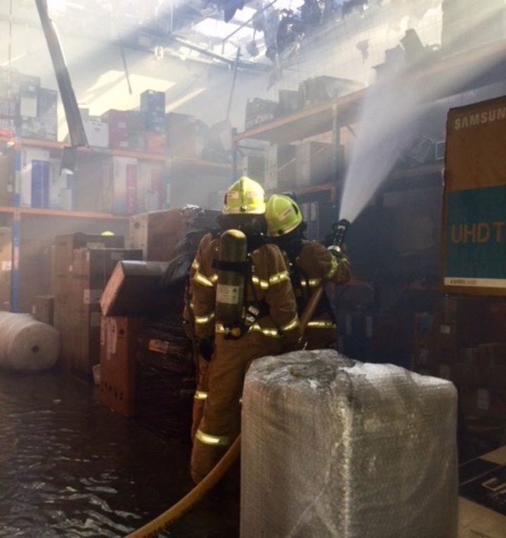 Firefighters battle the blaze inside a storeroom.
