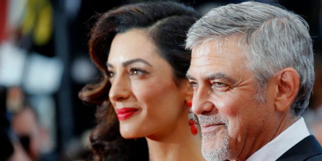 Actor George Clooney and wife Amal Clooney arrive at The Universal Premiere of Hail, Caesar! at the Regency Village Theatre, in Westwood, California, February 1, 2016 / AFP / Valerie Macon (Photo credit should read VALERIE MACON/AFP/Getty Images)
