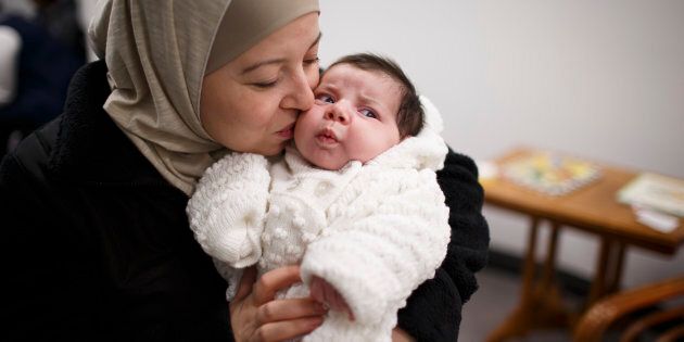 INDIANAPOLIS, IN - FEBRUARY 6: Waed Al-Hamoud, 35, kisses Selena, her 1-month-old daughter, at the Exodus Refugee Immigration offices in Indianapolis, Indiana on Monday, Feb. 6, 2017. In 2014, Al-Hamoud and her family fled Damascus and resettled in Indianapolis. They were the first family to relocate in Indianapolis from war-torn Syria. (Photo by James Brosher for The Washington Post via Getty Images)