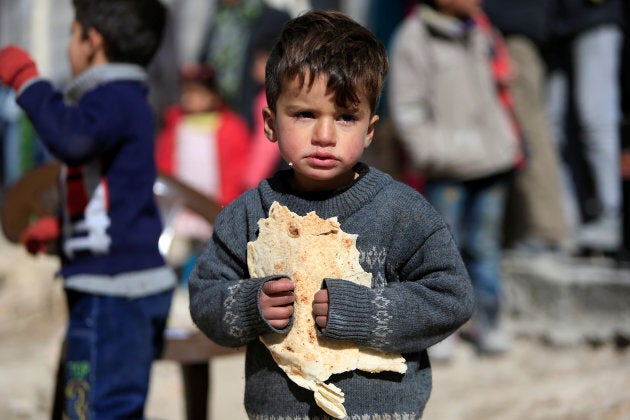 A displaced boy carries bread at a shelter in Jibreen, on the outskirts of Aleppo, Syria February 1, 2017.