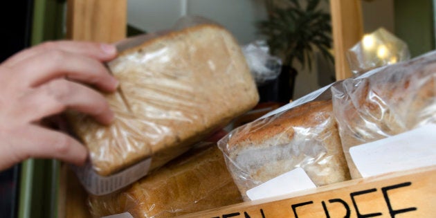 A woman hand picks up a Gluten Free loaf of bread.