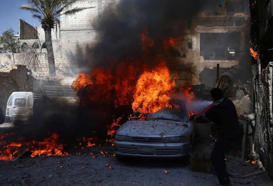 A man tries to put out a fire at a site hit by airstrikes in the rebel held besieged Douma neighbourhood of Damascus, Syria, February 26, 2017