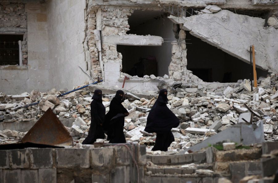Women walk near damaged buildings in the northern Syrian city of al-Bab, Syria March 13, 2017.