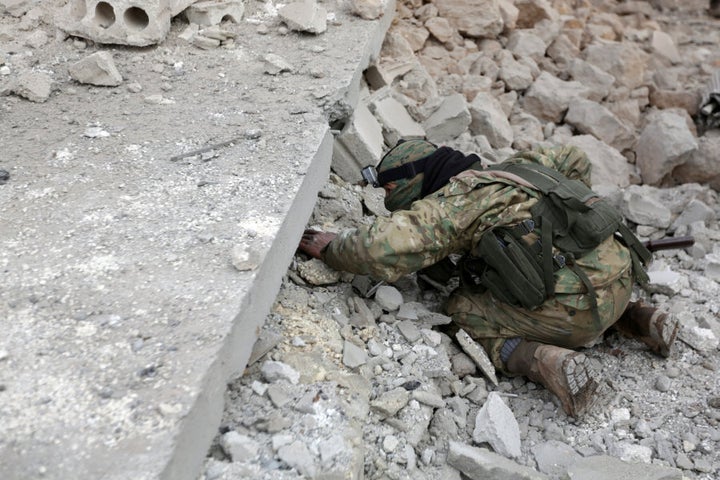 A rebel fighter looks for survivors under rubble of a damaged building after a car bomb explosion in Jub al Barazi east of the northern Syrian town of al-Bab, Syria January 15, 2017.