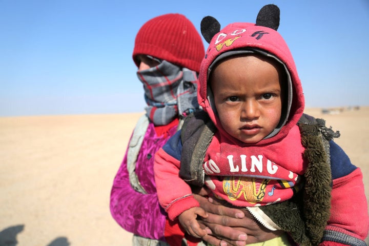 An internally displaced Syrian woman who fled Raqqa city carries a child in northern Raqqa province, Syria February 6, 2017.