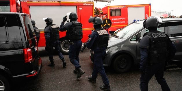 French policemen and firefighters secure the area at Paris' Orly airport on March 18, 2017 following the shooting of a man by French security forces.Security forces at Paris' Orly airport shot dead a man who took a weapon from a soldier, the interior ministry said. Witnesses said the airport was evacuated following the shooting at around 8:30am (0730GMT). The man fled into a shop at the airport before he was shot dead, an interior ministry spokesman told AFP. He said there were no people were wounded in the incident. / AFP PHOTO / CHRISTOPHE SIMON (Photo credit should read CHRISTOPHE SIMON/AFP/Getty Images)