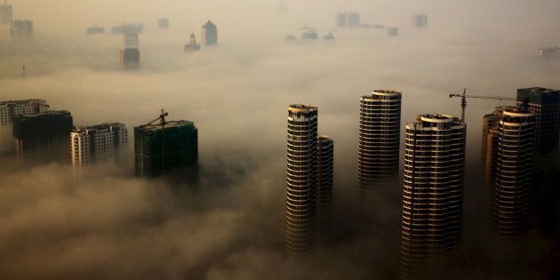 Buildings in construction are seen among mist during a hazy day in Rizhao, Shandong province, China, October 18, 2015. REUTERS/Stringer CHINA OUT. NO COMMERCIAL OR EDITORIAL SALES IN CHINA TPX IMAGES OF THE DAY