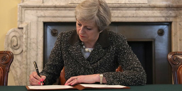 LONDON, ENGLAND - MARCH 28: British Prime Minister Theresa May in the cabinet office signs the official letter to European Council President Donald Tusk invoking Article 50 and the United Kingdom's intention to leave the EU on March 28, 2017 in London, England. After holding a referendum in June 2016 the United Kingdom voted to leave the European Union, the signing of Article 50 now officially triggers that process. (Photo by Christopher Furlong - WPA Pool/Getty Images)