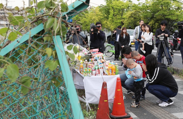 保育園児らの列に車が突っ込んだ事故現場で手を合わせる人たち＝5月9日午前、大津市