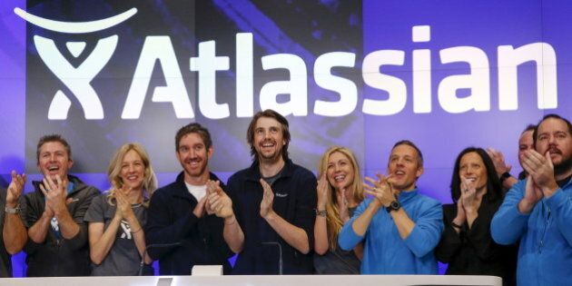 Mike Cannon-Brookes (C), co-founder and CEO of Atlassian Software Systems, and Scott Farquhar (3rd L), co-founder and CEO of Atlassian Software Systems, smile during it's opening PO at the Nasdaq at a MarketSite in New York, December 10, 2015. Atlassian Corporation Plc raised $462 million in its initial public offering in New York on Wednesday, as investors gave the Australian software company a warmer reception versus other stock market hopefuls in the technology sector this year. REUTERS/Shannon Stapleton