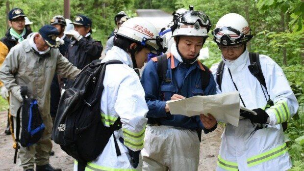 Japanese police rescue workers looking for 7 year old Yamoto.