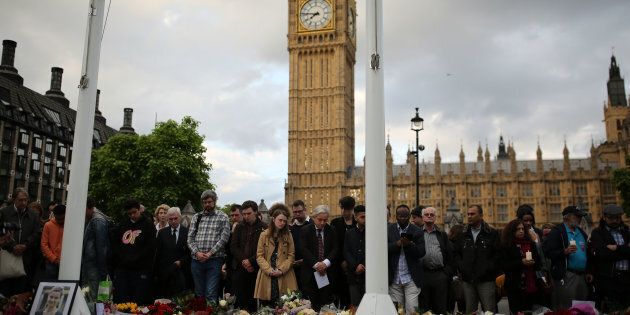 LONDON, UNITED KINGDOM - JUNE 17: People stand near the tributes and flowers as they attend a vigil in memory of Labour MP Jo Cox in Parliament Square on June 17, 2016 in London, England. The Labour MP for Batley and Spen was about to hold her weekly constituency surgery in Birstall Library yesterday when she was shot and stabbed in the street on June 16. A 52-year old man is being held in Police custody in connection with the death. (Photo by Dan Kitwood/Getty Images)